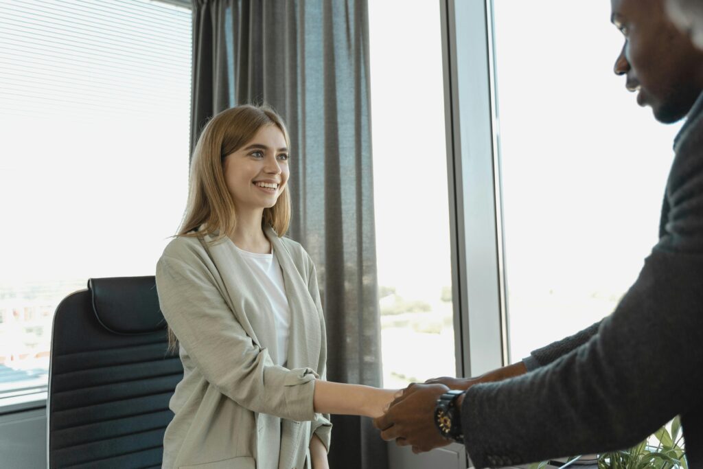 woman and mad shaking hands in a office setting